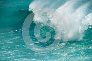 Turquoise ocean wave breaking