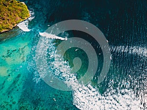 Turquoise ocean with waves and surfers at lineup. Aerial view