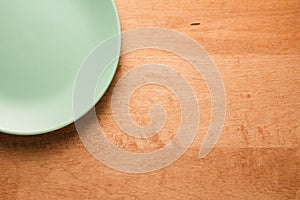 Turquoise plate on a wooden table, top view