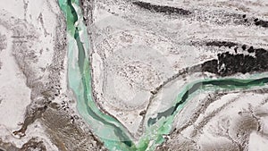 Turquoise river at frozen landscape in winter