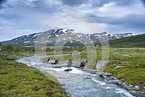 Turquoise River landscape and Arasluokta sami indigenous settlement