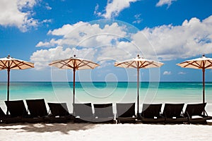 Turquoise sea, deckchairs, white sand and beach umbrellas.