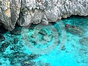 Turquoise sea detail, transparent water behind cliff