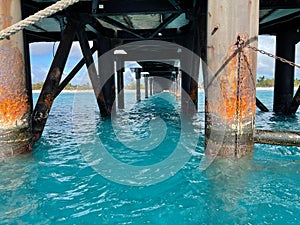 Turquoise seawater near the pilings of wooden dock