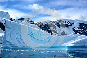 Turquoise shiny iceberg with texture in bright water of  Southern Ocean, Pradise Bay, Antarctica