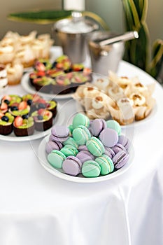 Turquoise and violet macarons. Wedding cakes on the table. Sweet desserts. Selective focus