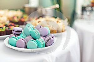 Turquoise and violet macarons. Wedding cakes on the table. Sweet desserts. Selective focus