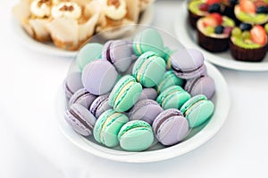 Turquoise and violet macarons. Wedding cakes on the table. Sweet desserts. Selective focus