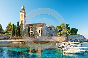 Turquoise water of Adriatic sea bay on Hvar island with franciscian monastery and boats in Dalmatia region, Croatia at