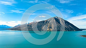 The turquoise water of Lake Ohau surrounded by the snow capped southern alps mountain range