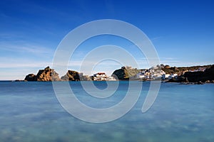 turquoise waters on the beaches of Menorca with the hamlet of Sa Mesquida in the background