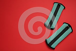 Turquoise weighting agents on red background, flat lay. Space for text