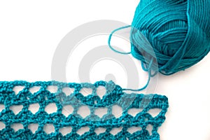 Turquoise yarn skein wound and crochet sample with white copy space background