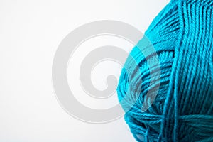 Turquoise yarn skein wound with white copy space background