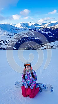 Turrach - A girl sitting on the snow with her snowboard