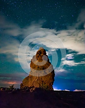 Turret arch at night with clouds and stars in Arches National Park