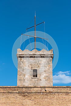 Turret of Montjuic Fortress with sun clock over blue sky. Barcelona, Spain