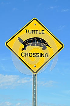 Turtle crossing sign in blue sky