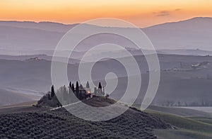 The Tuscan countryside in the province of Siena shrouded in morning mist before the dawn of a new day
