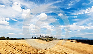 Tuscan countryside in a summer sunny day. Rural houses on the to