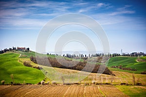 Tuscan hill with row of cypress trees and farmhouse. Tuscan landscape. Italy