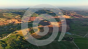 Tuscany aerial view, flying over vineyards, olive fields, and traditional houses