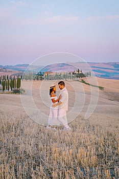 Tuscany, Crete Senesi rural sunset landscape. Countryside farm, cypresses trees, green field, sun light and cloud. Italy