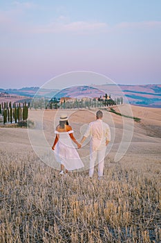 Tuscany, Crete Senesi rural sunset landscape. Countryside farm, cypresses trees, green field, sun light and cloud. Italy