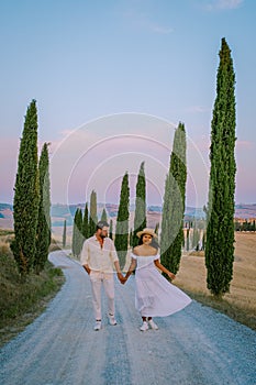 Tuscany, Crete Senesi rural sunset landscape. Countryside farm, cypresses trees, green field, sun light and cloud. Italy