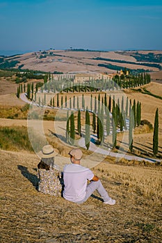 Tuscany, Crete Senesi rural sunset landscape. Countryside farm, cypresses trees, green field, sun light and cloud. Italy