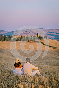 Tuscany, Crete Senesi rural sunset landscape. Countryside farm, cypresses trees, green field, sun light and cloud. Italy