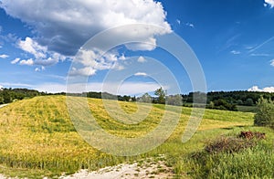 Tuscany, Italy. Rural sunset landscape. Countryside meadows, green field, sun light and clouds