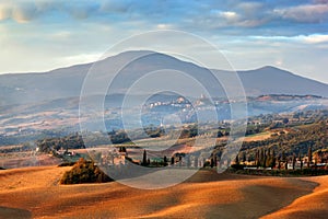 Tuscany landscape at sunrise. Tuscan farm house, cypress trees, hills.