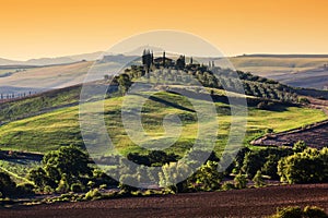 Tuscany landscape at sunrise. Tuscan farm house, green hills.