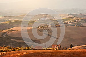 Tuscany landscape at sunrise. Tuscan farm house, vineyard, hills.