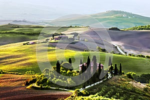 Tuscany landscape at sunrise. Tuscan farm house, vineyard, hills.