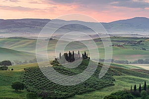 Tuscany rural landscape, foggy morning landscape with green rolling hills of countryside farm in Val d\'Orcia, Italy