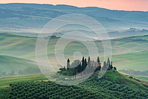 Tuscany rural landscape, foggy morning landscape with green rolling hills of countryside farm in Val d\'Orcia, Italy