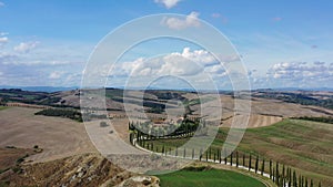 Tuscany rural landscape with house, cypress road and hills. Aerial view.