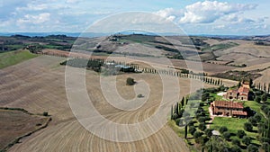 Tuscany rural landscape with house, cypress road and hills. Aerial view.