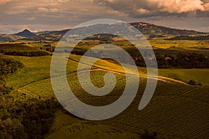 Tuscany, sunset landscape panorama of the city of Volterra with hills, vineyards and classic dirt road in foreground