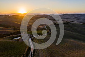 Tuscany, Val d`Arbia, Siena October 19, 2019. Aerial view of a rural landscape during sunset. Rural farm, cypress trees