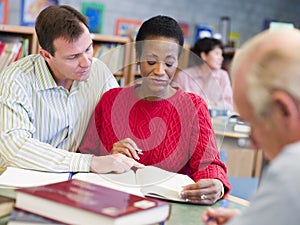 Tutor assisting mature student in library