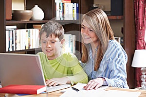 Tutor Helping Boy Studying At Home