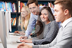 Tutor Helping Students Working At Computer