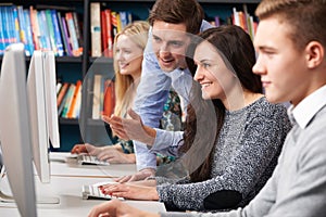 Tutor Helping Teenage Students Working At Computers