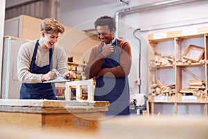 Tutor With Male Carpentry Student In Workshop Studying For Apprenticeship At College photo