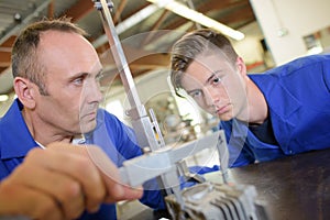 Tutor using vernier guage apprentice watching photo