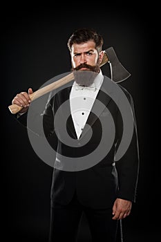 Tuxedo party boss. brutal man hispter hold axe black background. confident businessman formal suit. serious male barber