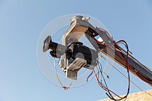 Professional TV camera on a crane with blue sky.